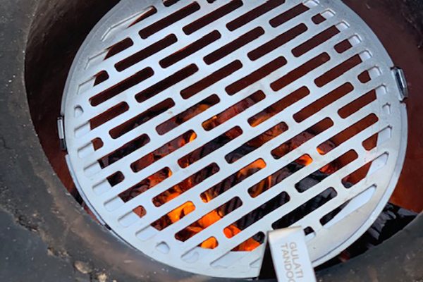 GULATI TandoorDISC grill grate inside a tandoor over glowing charcoal